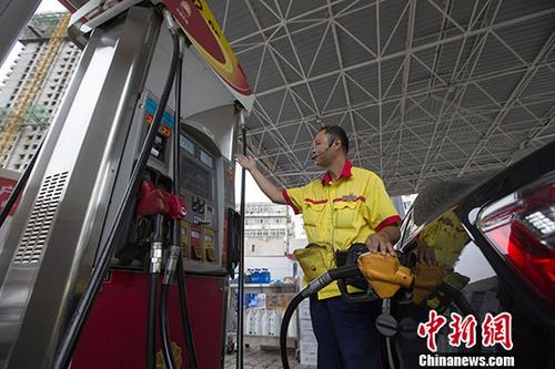 資料圖：一加油站工作人員給車輛加油。中新社記者張?jiān)茢z